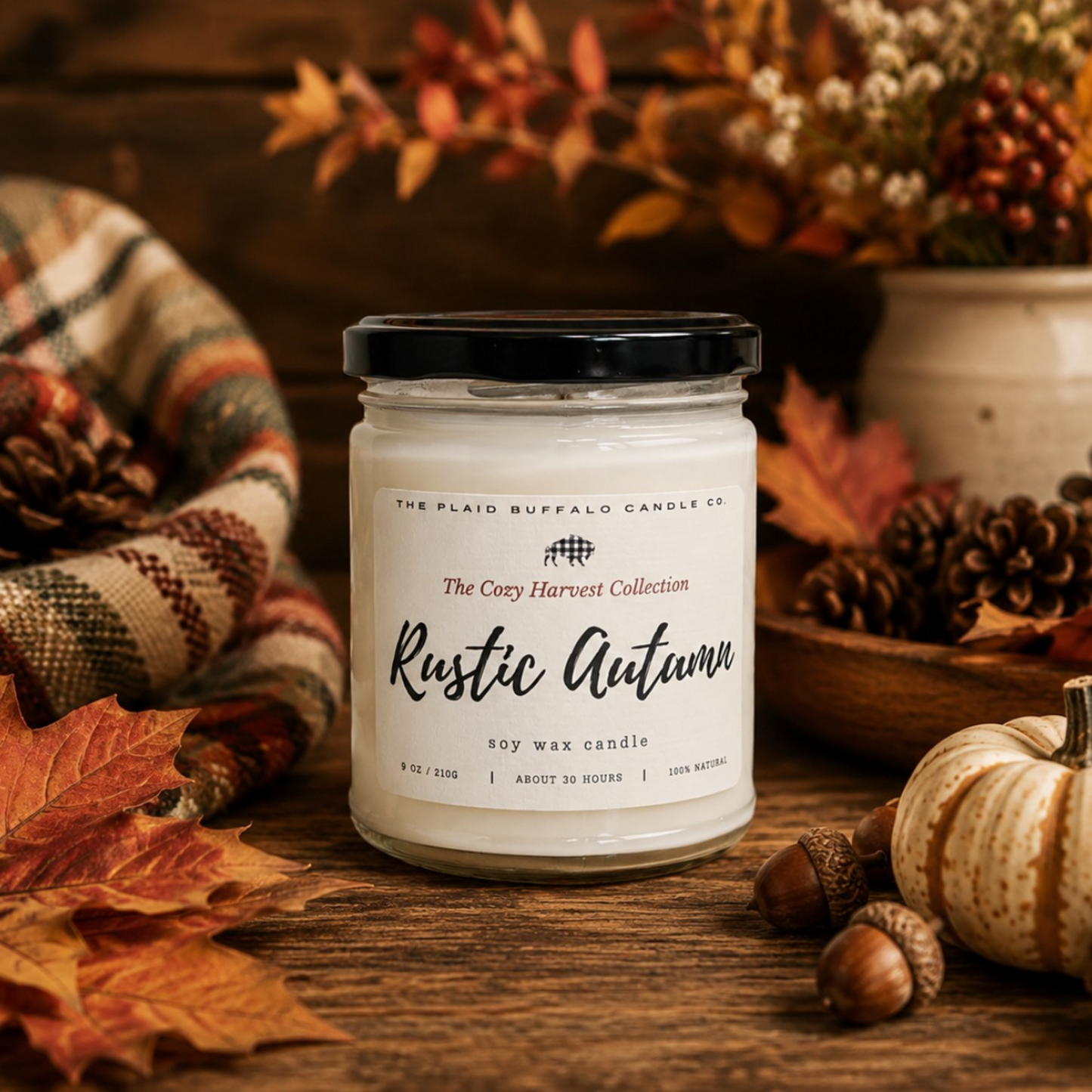 Rustic Autumn soy candle by Plaid Buffalo Candle Co. displayed with fall leaves, pinecones, acorns, pumpkins, and a plaid blanket.
